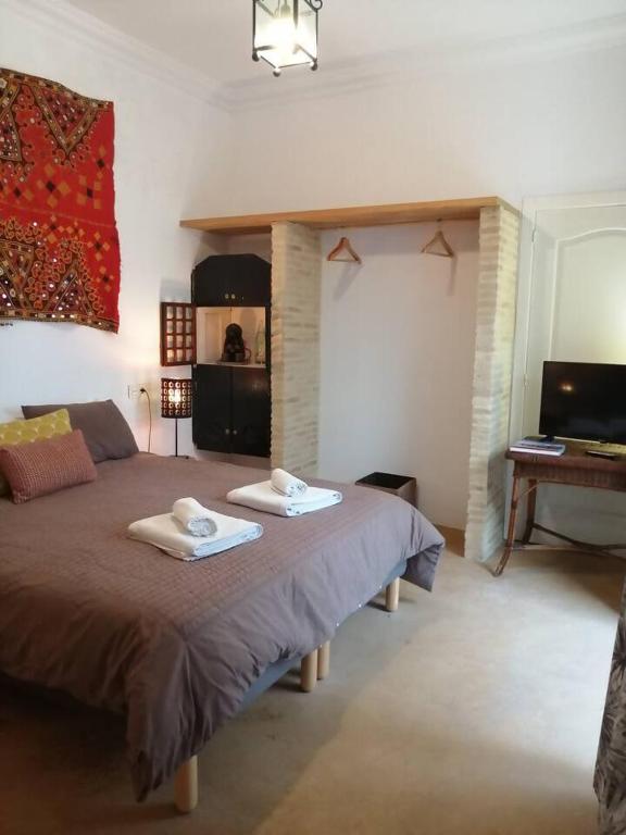 a bedroom with a bed with two towels on it at el rinconcito in Sanlúcar de Barrameda