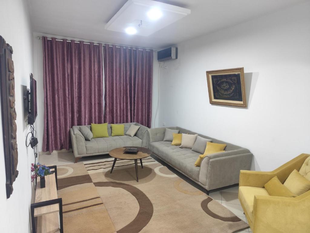 a living room with two couches and a table at immeuble brini in Kairouan