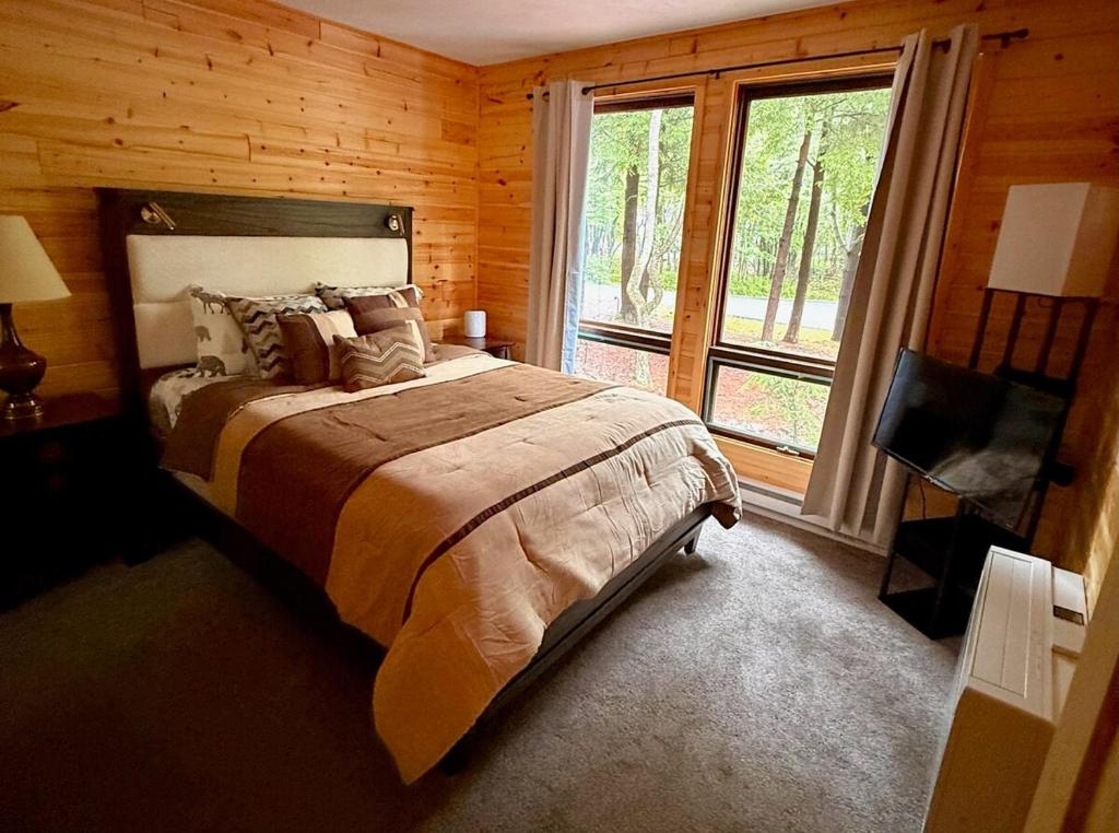 a bedroom with a bed and a large window at Cozy Poconos Cabin in Blakeslee