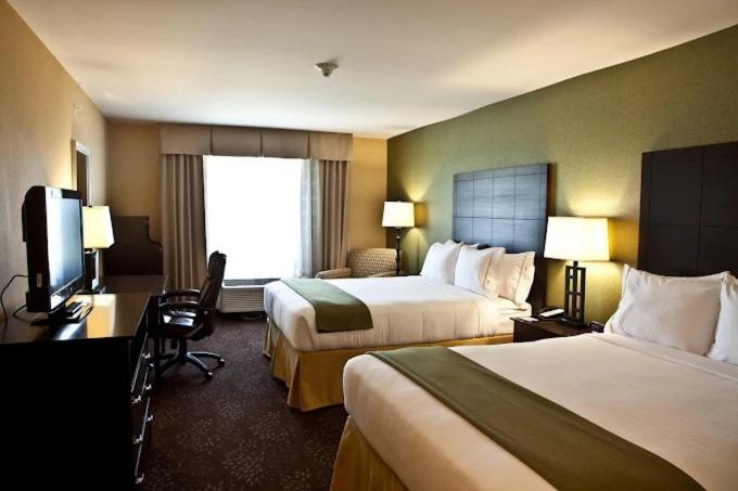 a hotel room with two beds and a flat screen tv at Holiday Inn Express and Suites Dimondale-Lansing 