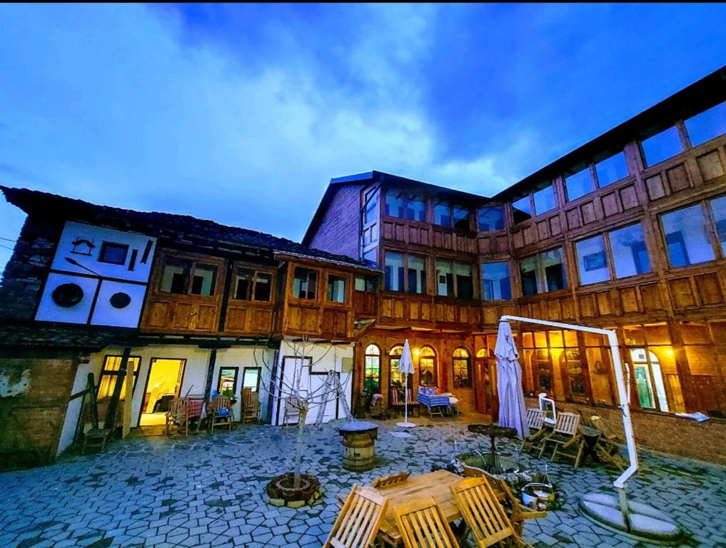 a building with a table and chairs in front of it at Etno kuca Petrovic in Štrpce
