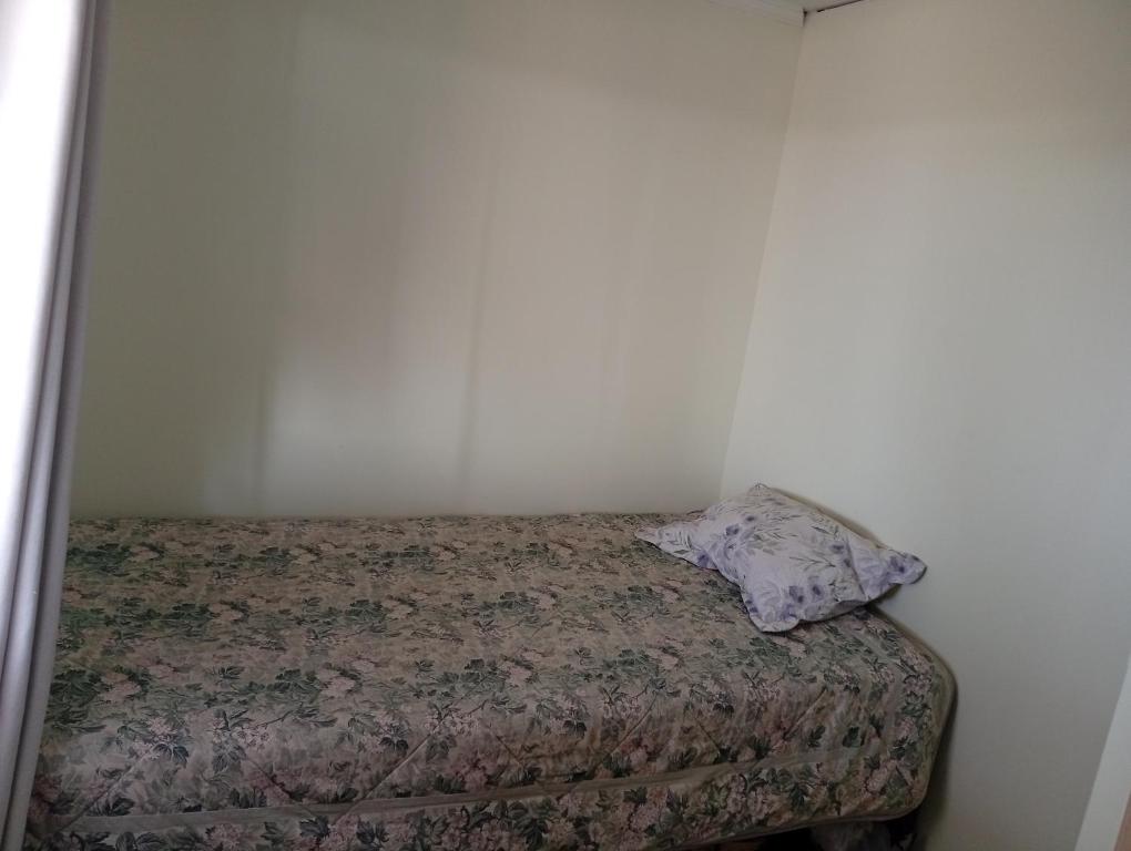 a bed in a room with a pillow on it at Cabaña con vista al mar in Tomé