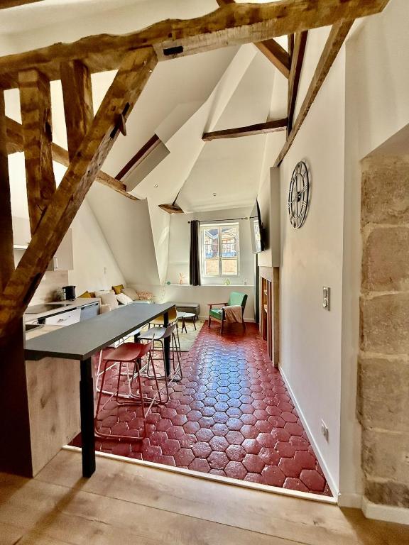 an attic room with a table and chairs and a clock at Perfect pied-à-terre in Dijon in Dijon