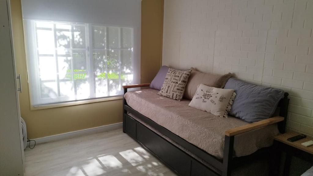 ein Sofa in einem Zimmer mit Fenster in der Unterkunft La Comarca Tinyhouse Monoambiente in Puerto Iguazú