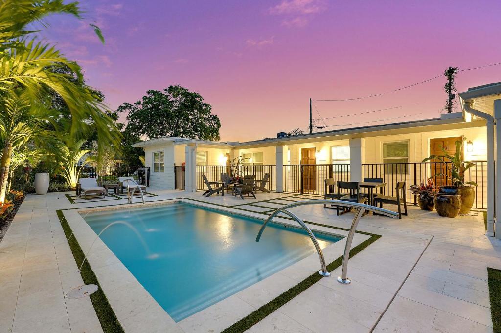 a swimming pool in front of a house at New Studio Apartment w Kitchen - A in West Palm Beach