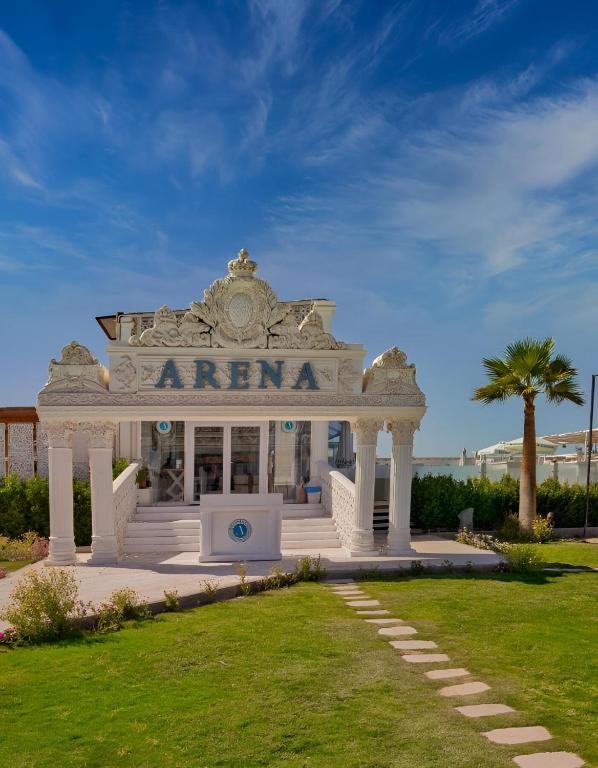 a white entrance to a building with a palm tree at Selena Bay Beach Resort in Hurghada