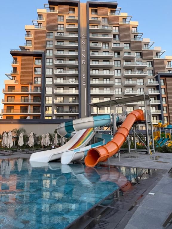 a water slide in front of a large building at Riverside Life Residence in Iskele