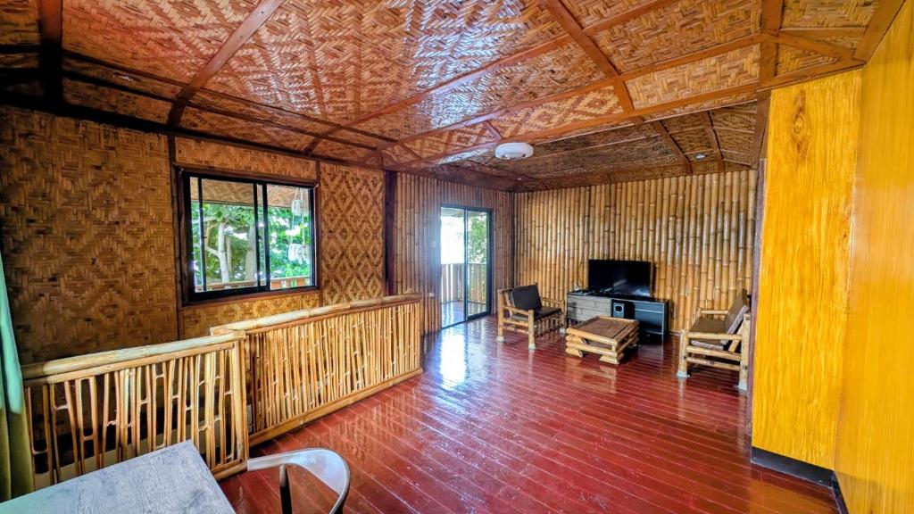 un soggiorno con boiserie e televisione di Oceana a Padre Burgos