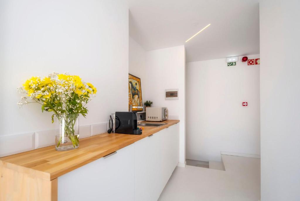 een vaas met gele bloemen op een toonbank in een kamer bij Primavera House in Faro