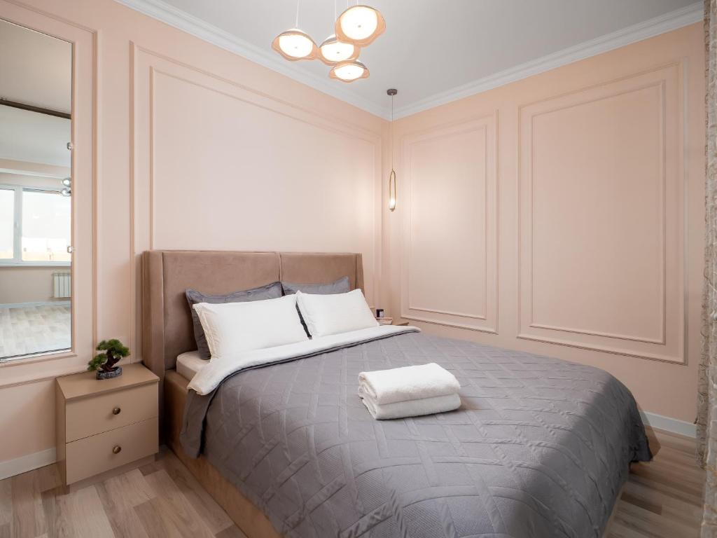 a bedroom with a large bed with white pillows at Seven Elite Apartments by Mega Mall in Almaty