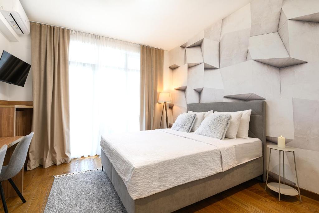 a bedroom with a large bed and a large window at inJoy in Belgrade