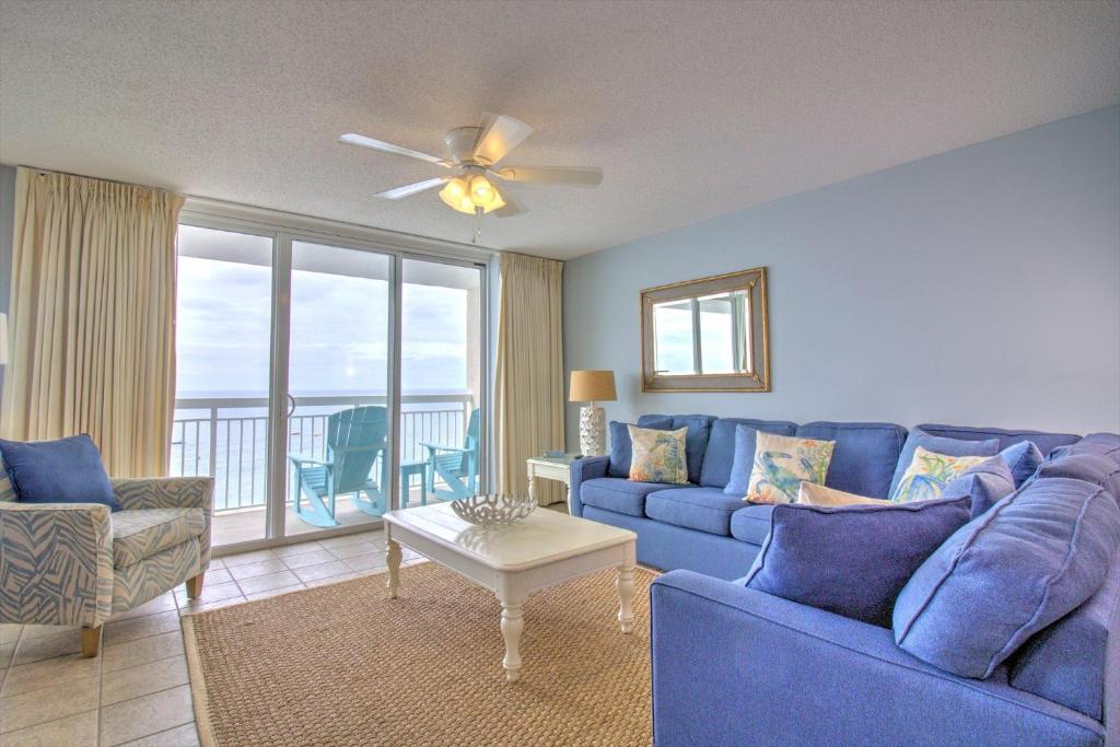 a living room with a blue couch and a table at Crescent Shores North - 1302 in Myrtle Beach