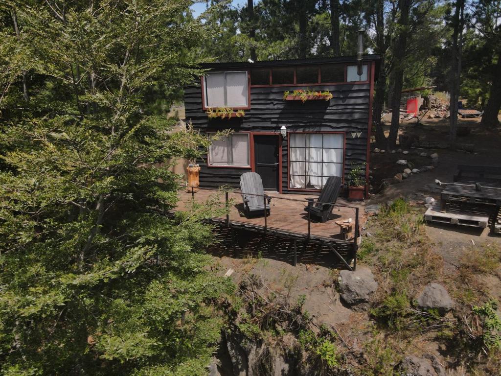 an aerial view of a log cabin with two chairs at Cabaña con terraza vista al río in Melipeuco