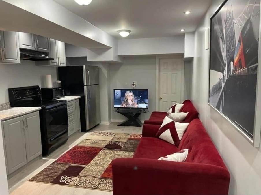 een woonkamer met een rode bank en een tv bij Peace Apartment in Brampton