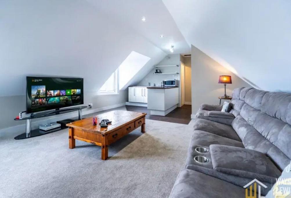 a living room with a couch and a tv at The Whitehouse in Pontypridd