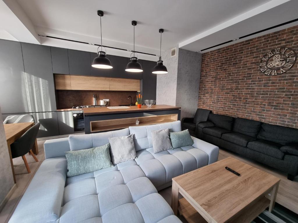 a living room with a white couch and a brick wall at Diplomat Lev Tolstoi 74 street Apartments in Chişinău