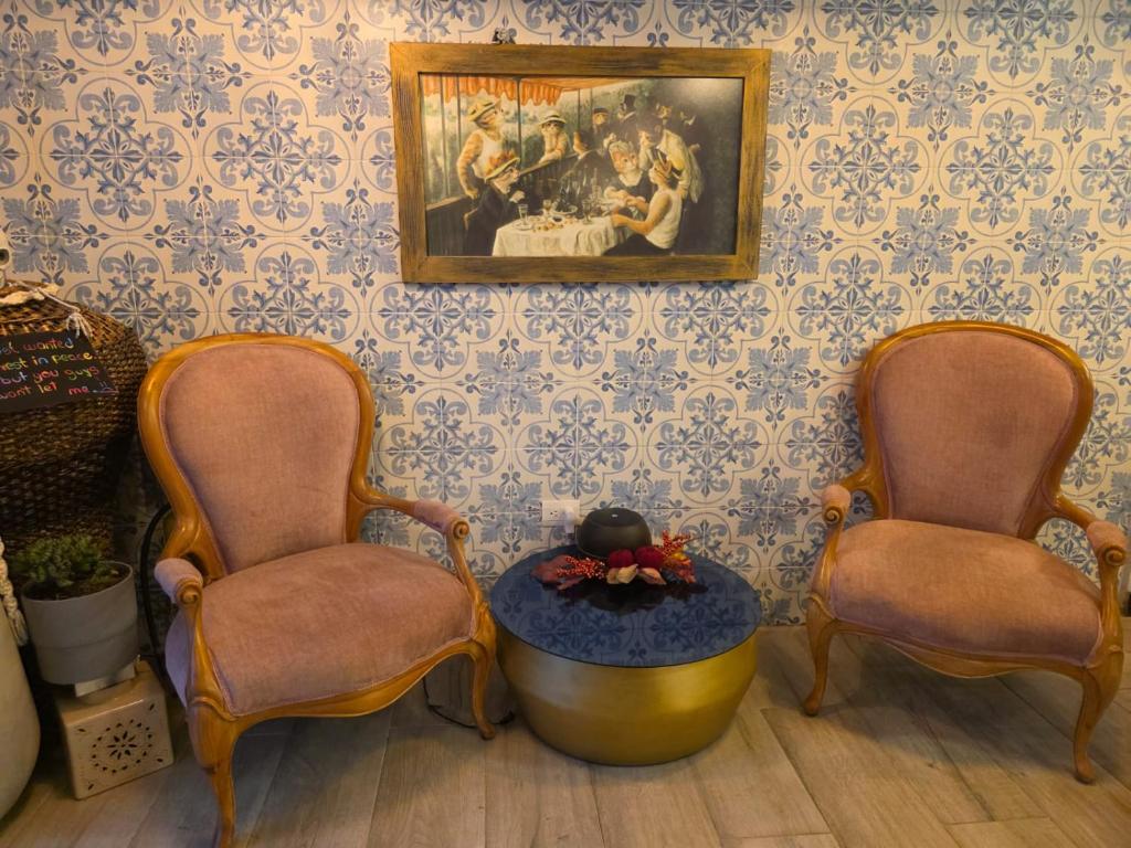 a room with two chairs and a painting on the wall at Freyja Hostal Boutique - Café Bistró in Bogotá