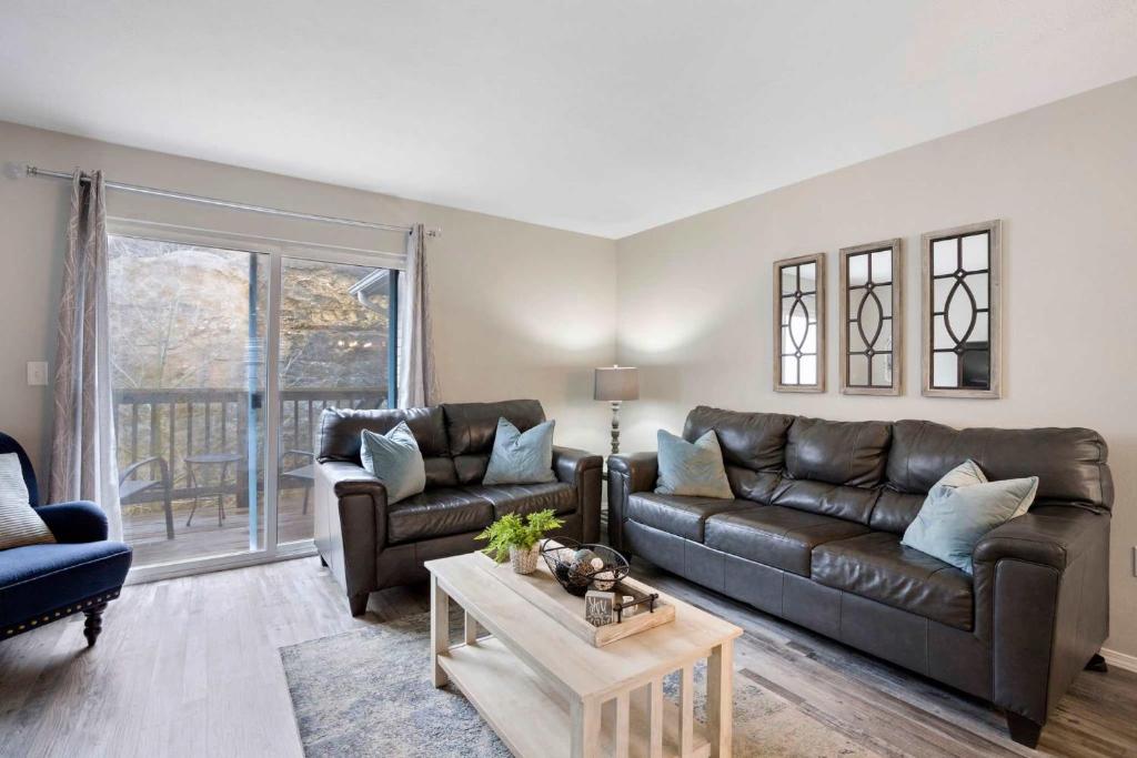 a living room with a leather couch and a table at Rockwall Lodge - Close to Branson Strip in Branson