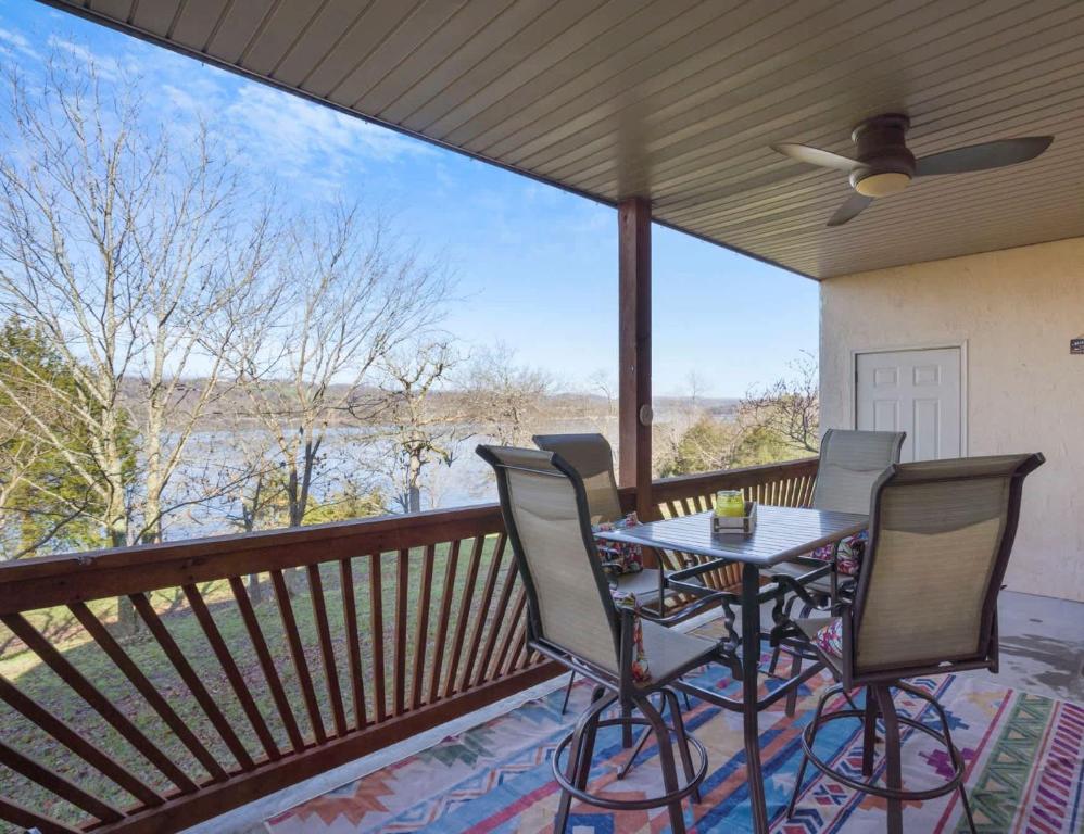 een terras met een tafel en stoelen op een balkon bij Lakefront Sanctuary - Table Rock Lake Adventures in Branson