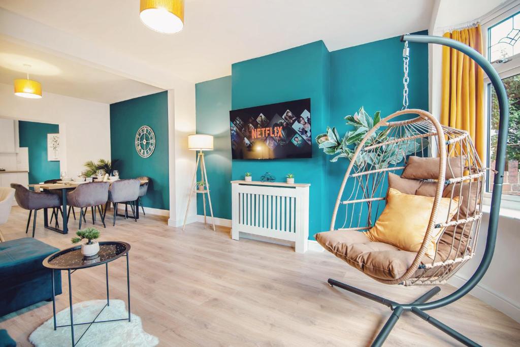 een woonkamer met een schommel en een eetkamer bij Open Haven Collective with Man Cave and Parking 10PPL in Handsworth