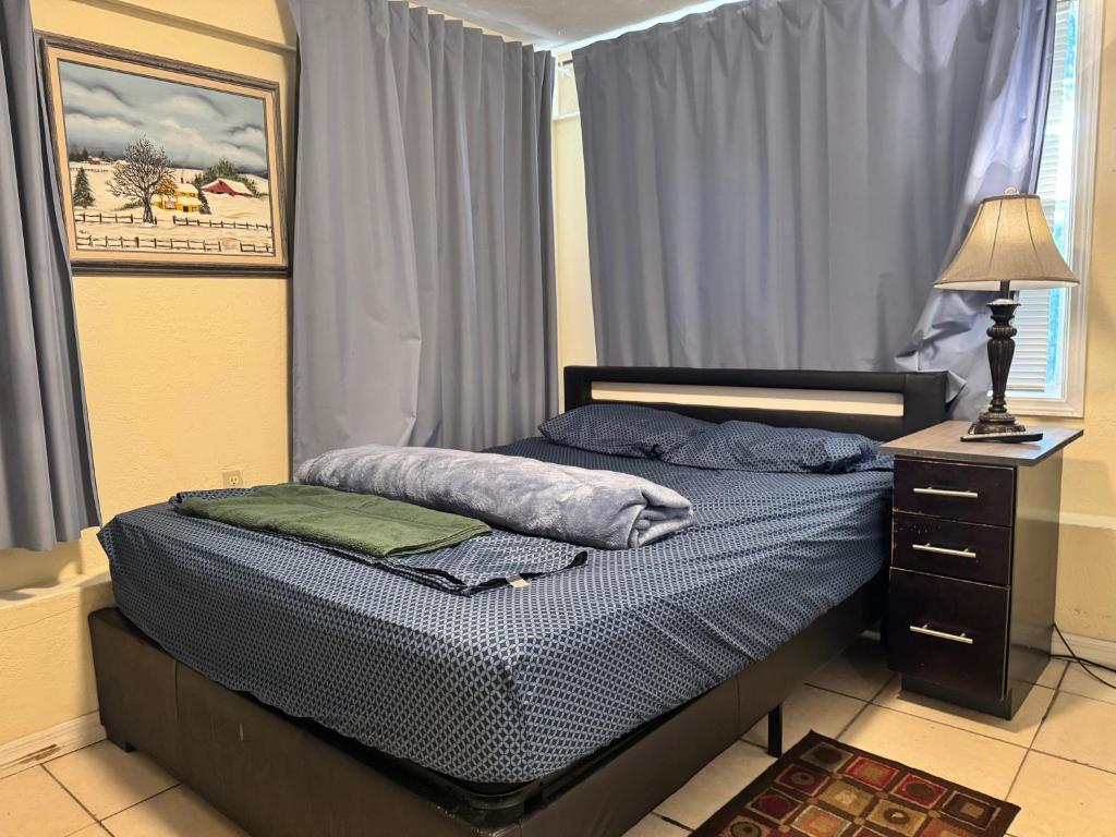a bedroom with a bed with a lamp and a dresser at Tampa Downtown property in Tampa