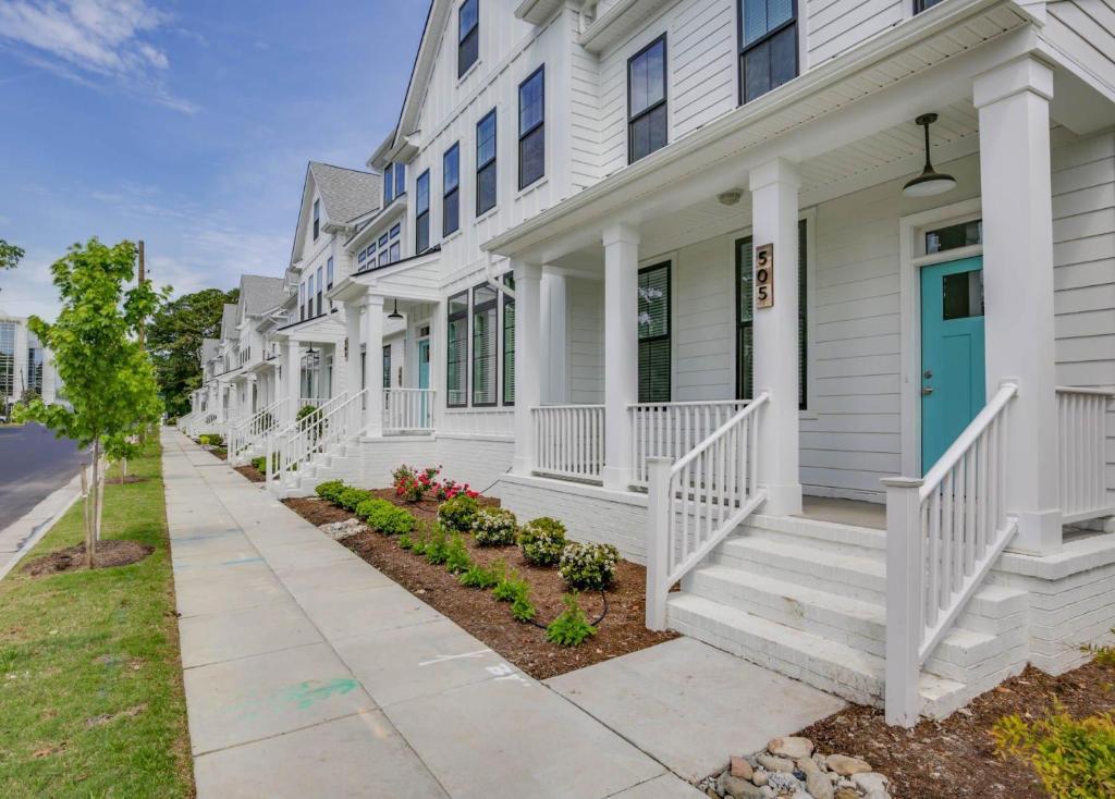 a white house with white stairs and a blue door at 519 The Great Neck House in Virginia Beach