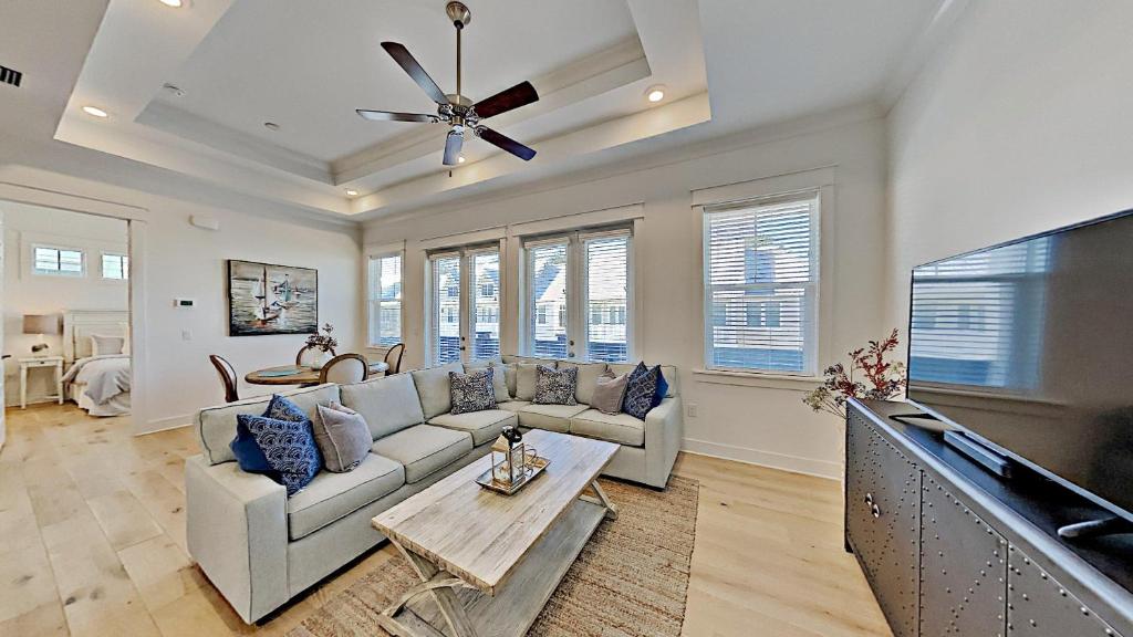 a living room with a couch and a flat screen tv at Settle By The Sea in Inlet Beach