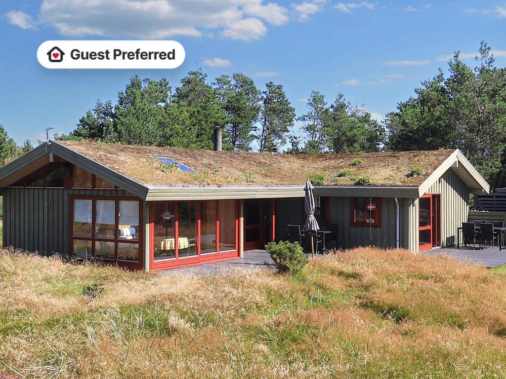 a house with a grass roof on top of a hill at 6 person holiday home in Blokhus-By Traum in Blokhus
