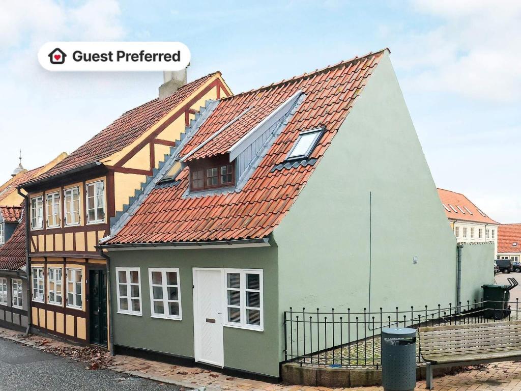 a house with a red roof and a black fence at 4 person holiday home in Rudkøbing-By Traum in Rudkøbing