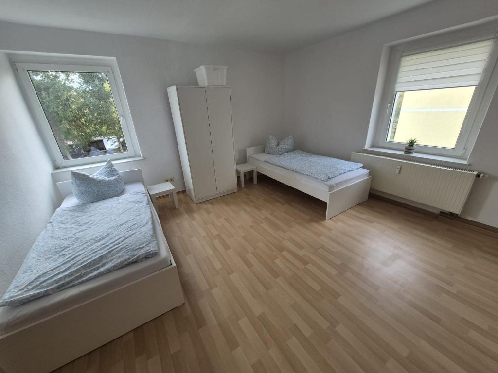 Habitación blanca con 2 camas y 2 ventanas en Monteurwohnung nähe Leuna, Halle und Leipzig, en Braunsbedra
