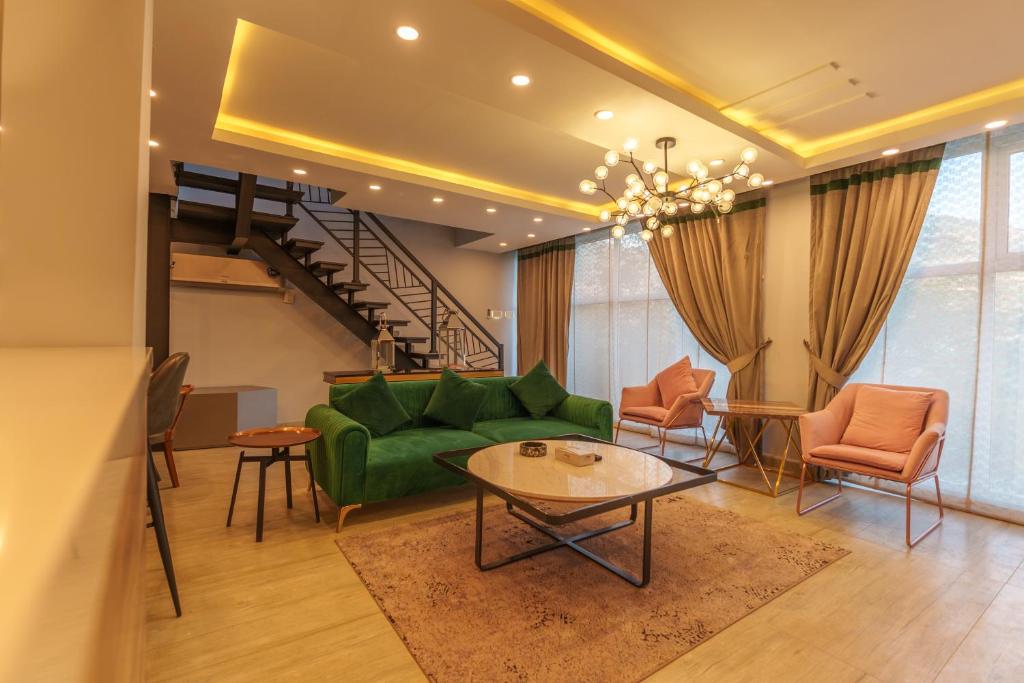 un salon avec un canapé vert et une table dans l'établissement Murree Hills Executive 3 Bedroom Cottage with Scenic View, à Murree