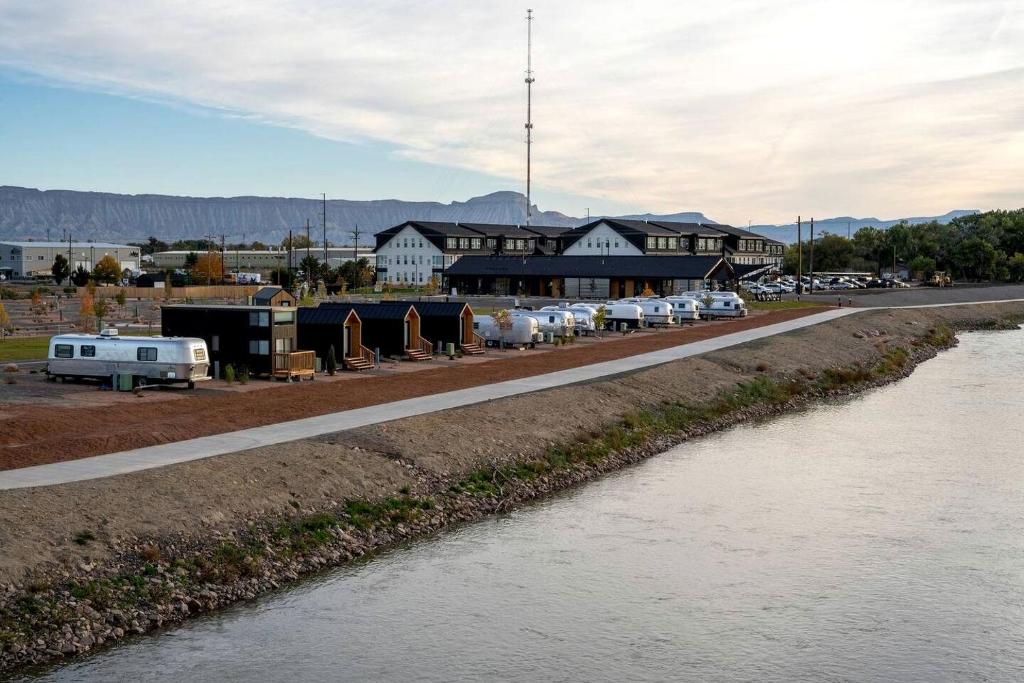 a road next to a river with cars parked on the side at Rustic Tiny House Glamping in Grand Junction: Authentic Rural Charm in Colorado in Grand Junction
