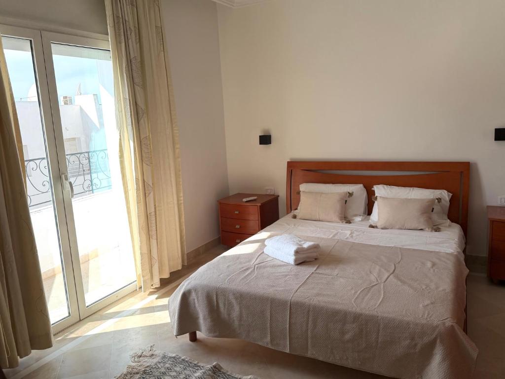 a bedroom with a bed and a large window at Casaflor Tunis in Berges Du Lac