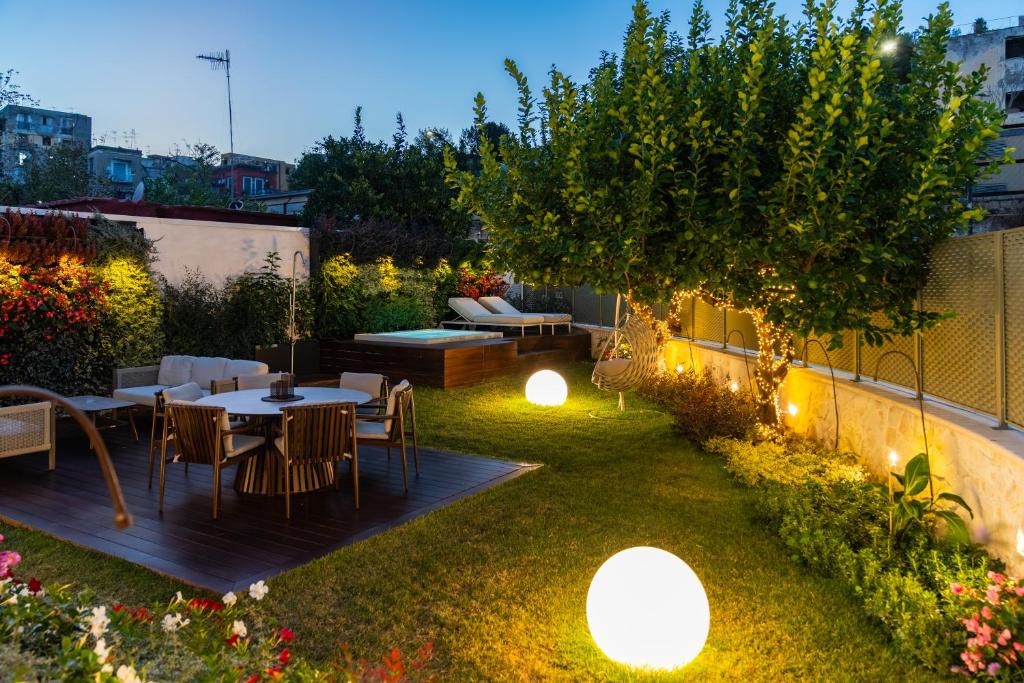 a garden with a table and chairs and lights at Dimora Botanica in Naples
