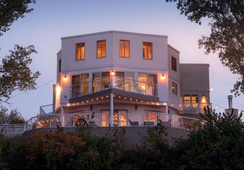 une grande maison blanche avec ses lumières allumées dans l'établissement Incredible Lakefront Villa with Gorgeus Sights and Fireplace in Gary, Indiana, à Miller