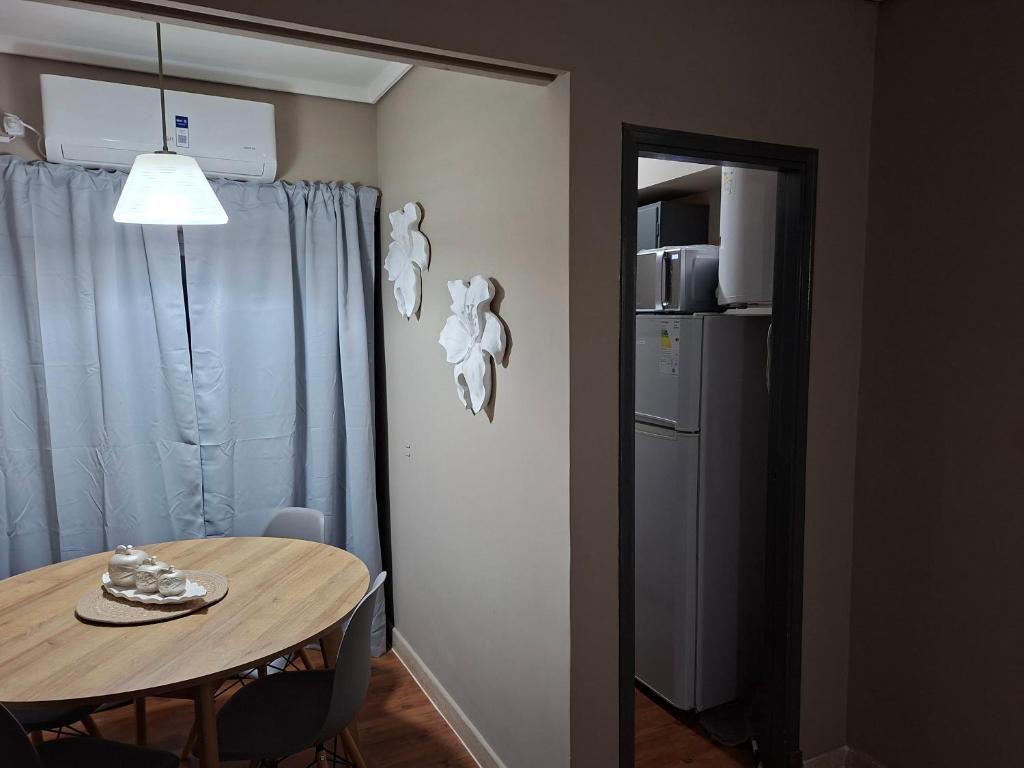 a dining room with a table and a refrigerator at Neptuno VI in Mar del Plata
