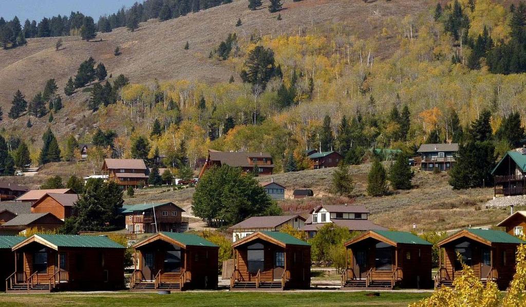 a group of houses in front of a mountain at Comfortable Lakefront Cabin near West Yellowstone, Montana in Lakeview
