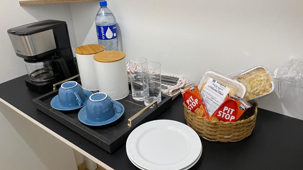 eine Theke mit einem Tablett mit Tassen und einer Kaffeemaschine in der Unterkunft Suite no centro de Doutor Pedrinho in Rio Forcação