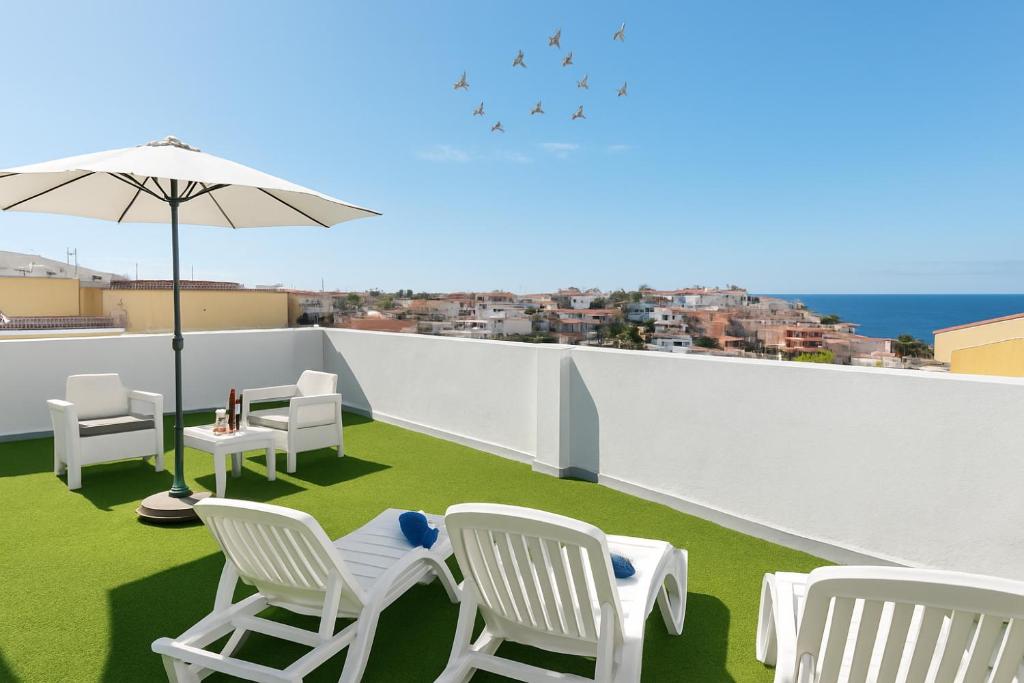 アルカラにあるLa Cala de Alcalá Luxuryの屋根の上の椅子と傘