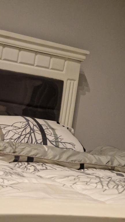 a close up of a bed with a white headboard at Breathtaking Nest 2, cosy and spacious in Kampala