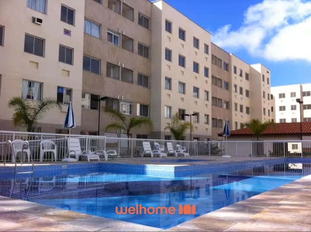 a hotel with a swimming pool in front of a building at Apartamento no Rio de Janeiro com Piscina e Lazer in Rio de Janeiro