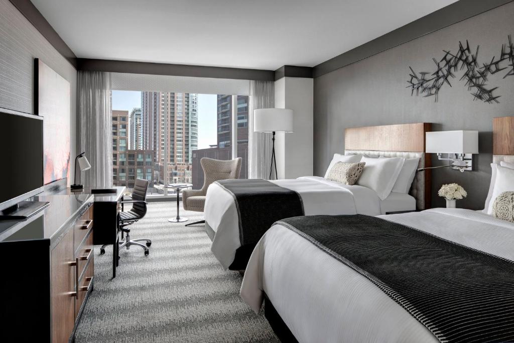 a hotel room with two beds and a desk at Loews Chicago Hotel in Chicago