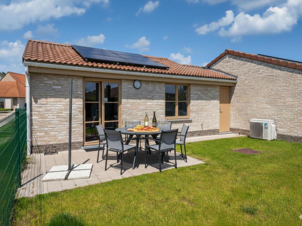 a patio with a table and chairs in a yard at Westhinder I H21 in Koksijde