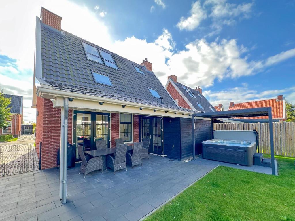 a house with a hot tub on a patio at Beach deluxe in Colijnsplaat
