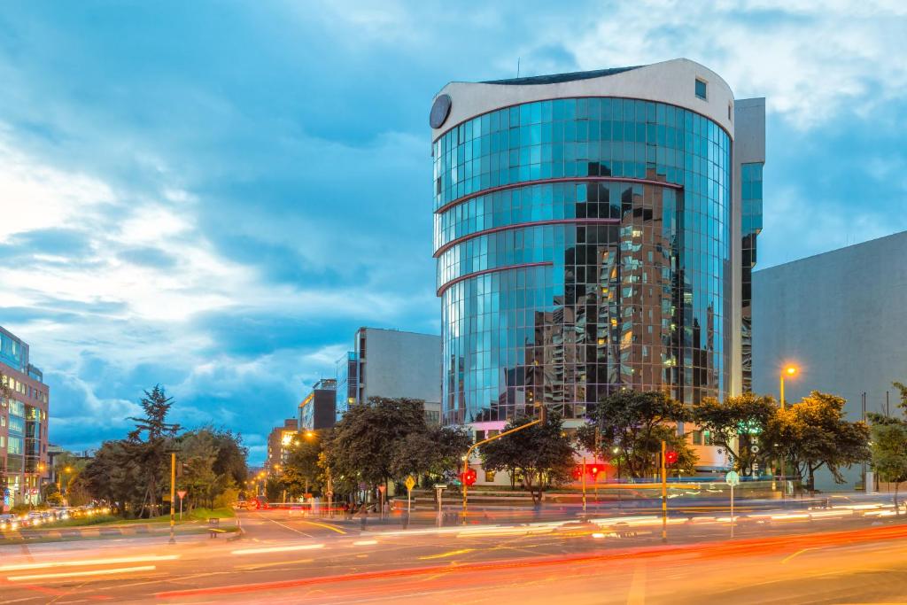 een hoog glazen gebouw met een straat ervoor bij Hotel Bogotá Regency Usaquén in Bogota