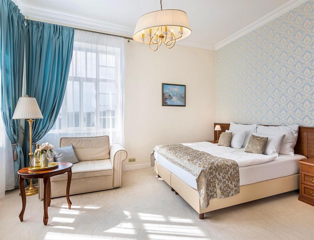 a bedroom with a bed and a couch at Hotel Katerina in Znojmo