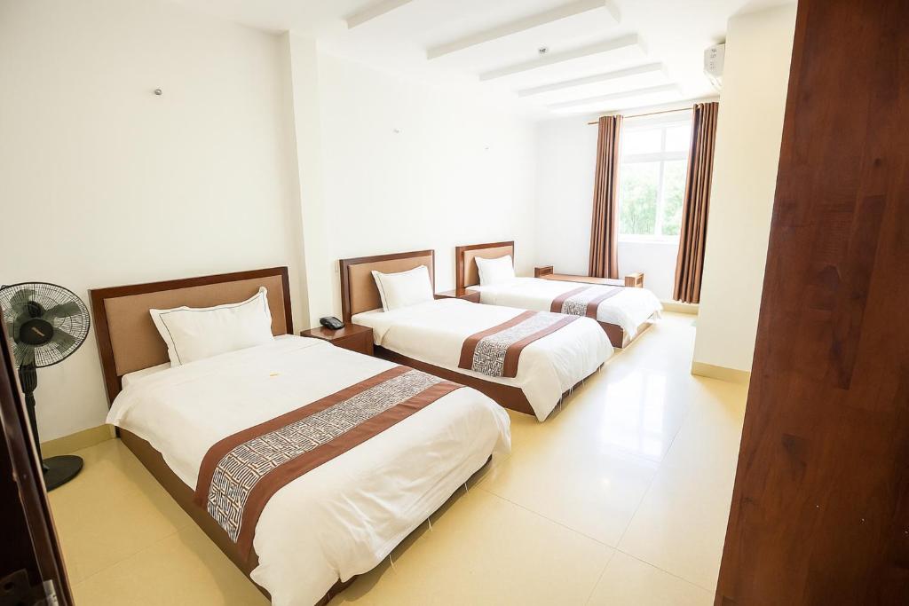 two beds in a room with white walls at SONG HONG VIEW HOTEL in Lao Cai