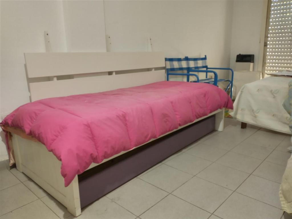 een bed met een roze deken erop in een kamer bij Quince 45 in La Plata