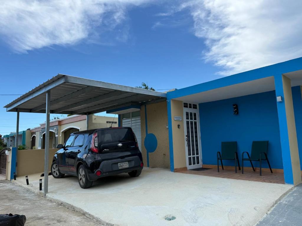 un coche aparcado en un estacionamiento junto a una casa en Colombiano boricua, en Quebradillas