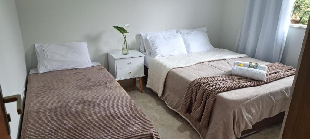 a bedroom with two beds next to a window at Casa Bello Monte in Venda Nova do Imigrante